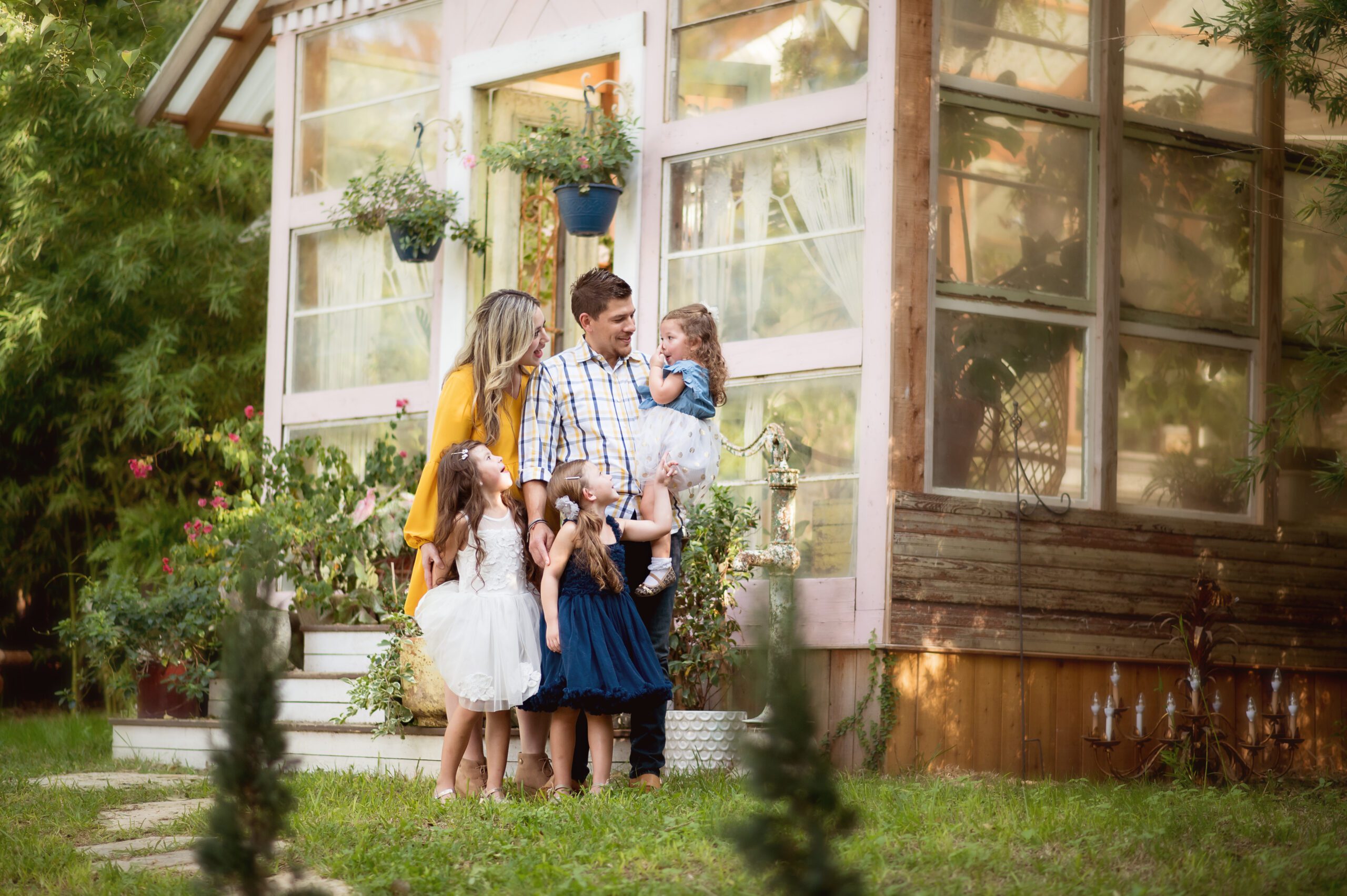 Family standing in front of greenhouse