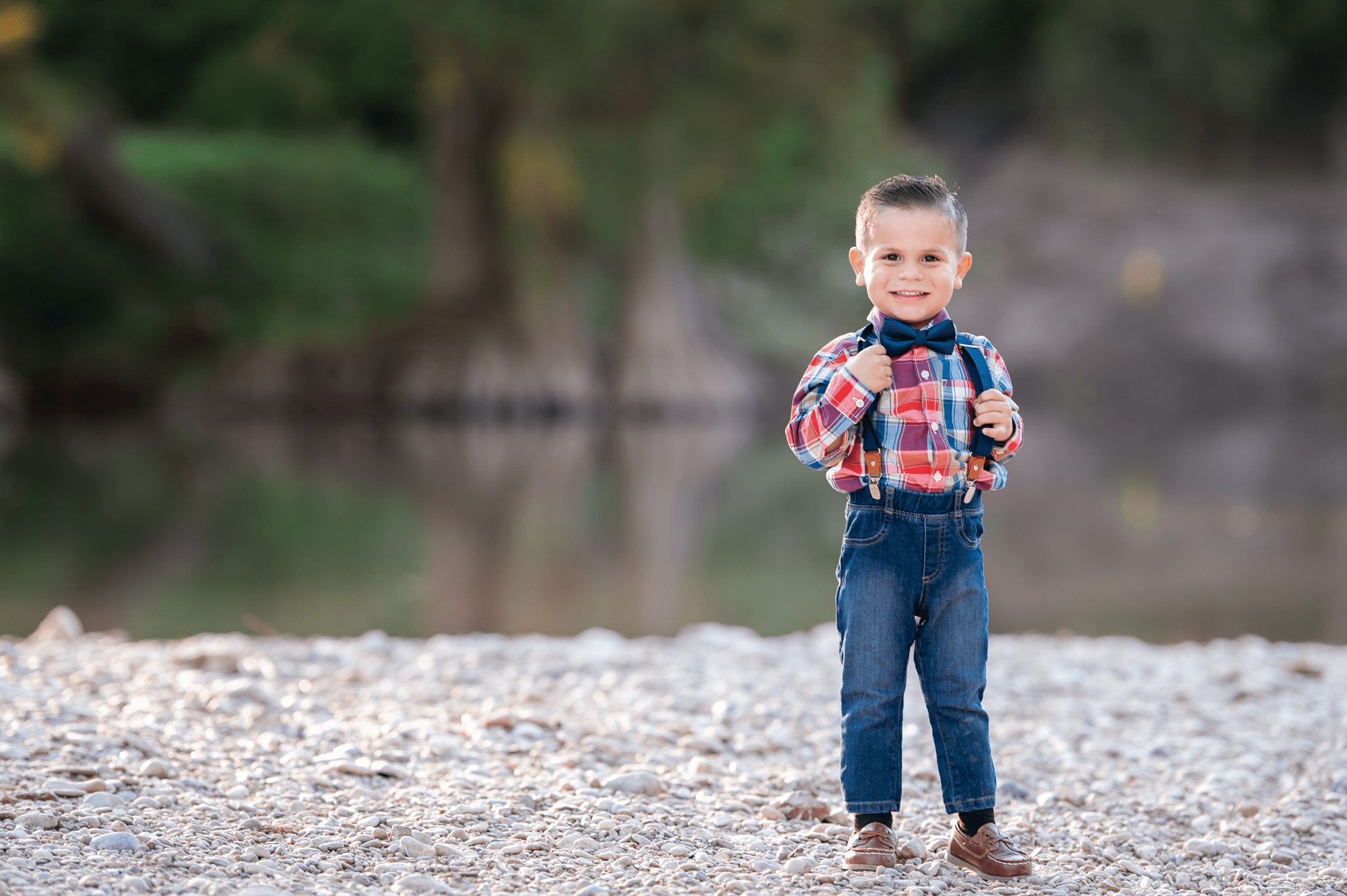 Boy with suspenders by the water